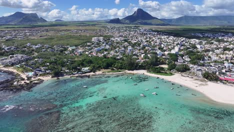 aerial view of a coastal town with turquoise water and mountains