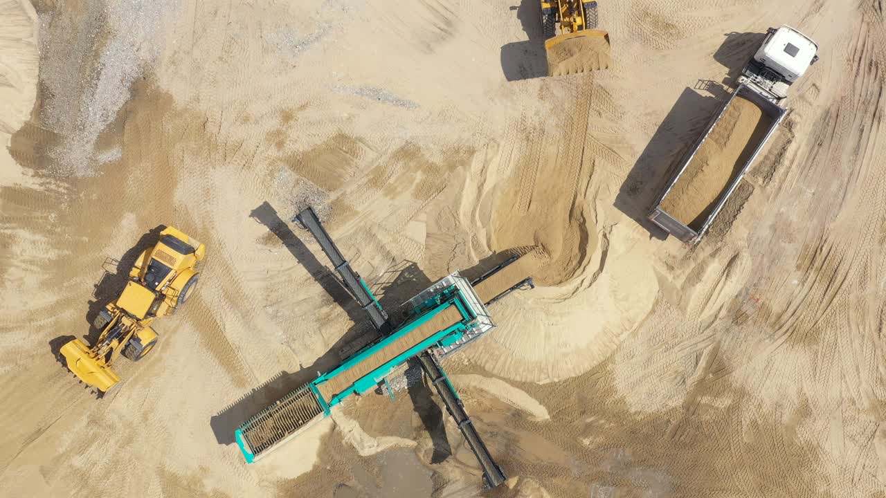 Luftfoto af en læssende bulldozer i et åbent stenbrud.