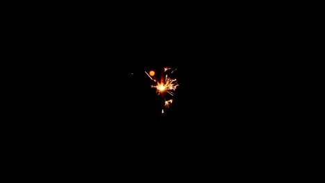 Static-shot-of-a-yellow-and-orange-sparkler-from-above-with-a-black-background