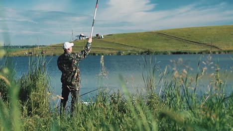 fisherman in camouflage clothes catches