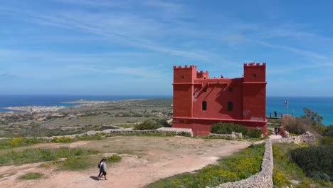 persone che camminano verso la torre rossa di mellieha, conosciuta anche come la torre di st. agatha