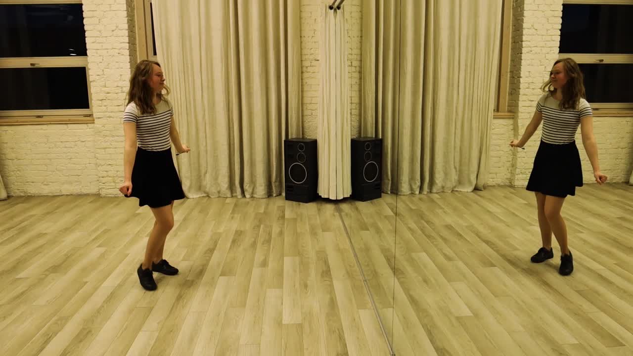 Zpomalený záběr na talentovanou náctiletou tanečnici, která tančí před zrcadlem.