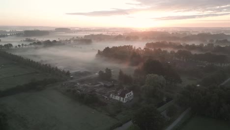 misty sunrise over a ruined farmhouse