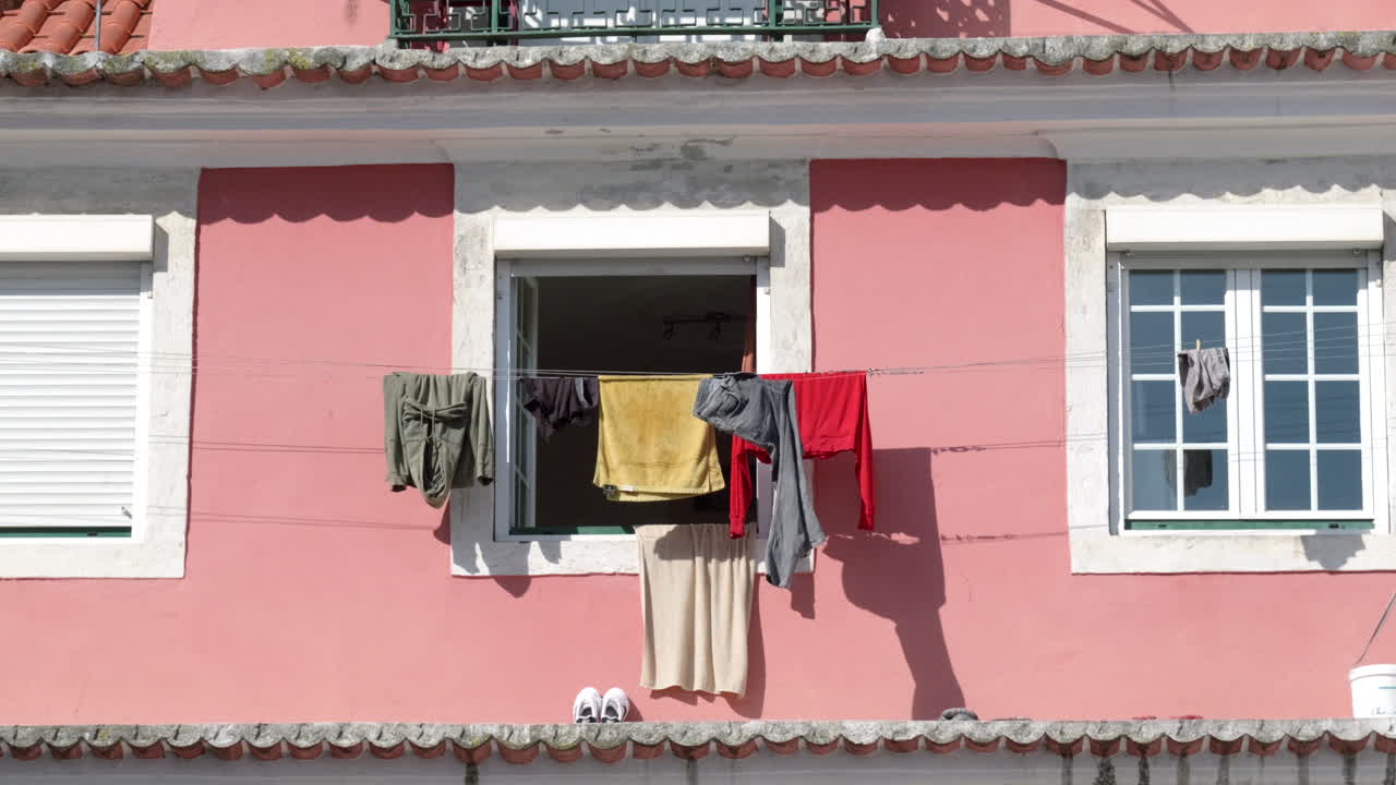 Clothes Laundry Hang Dry on Clothesline on Pink Building in Lisbon Portugal