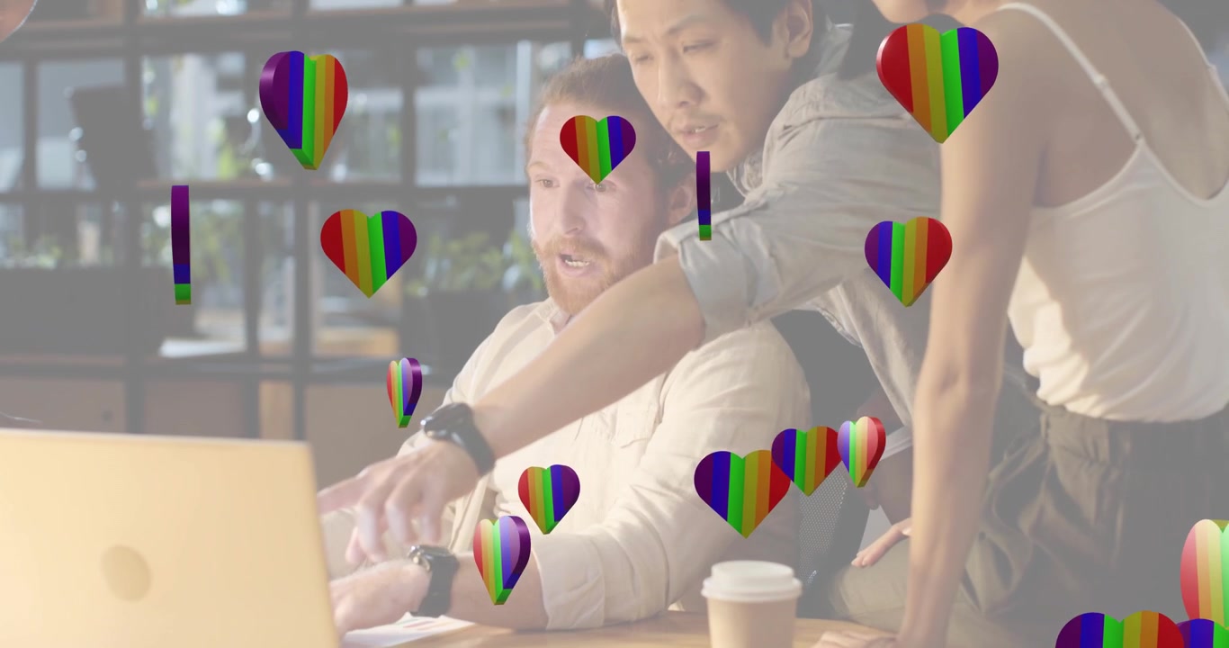 Businessman typing on laptop after rainbow hearts floating around desk collaborating with team