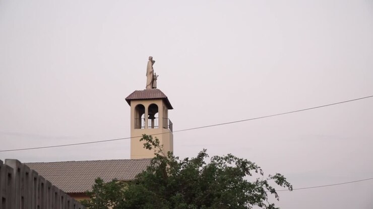 Campanile della chiesa e statua durante il tramonto a La Molina, Lima, Perù. Panoramica da sinistra a destra.