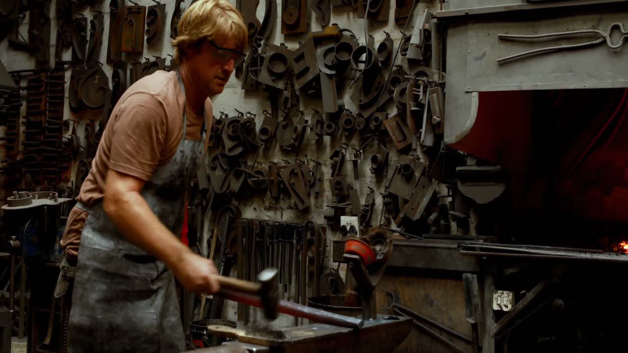 кузнец, стучащий горячим металлическим стержнем 4k