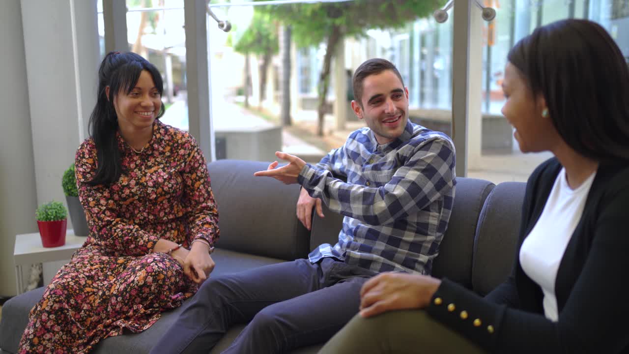 colegas multiétnicos sentados en el sofá en la oficina