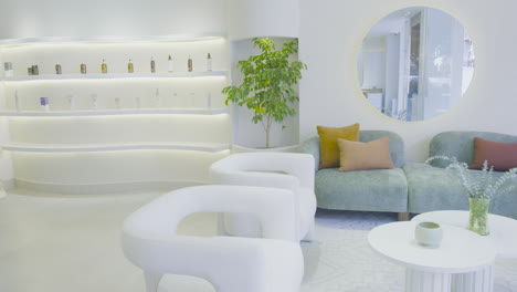 a soft panning shot reveals a modern reception room with a sleek bookshelf. the space is well-lit, with a clean design and decorative details.