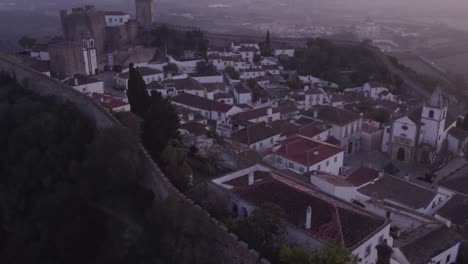 la histórica ciudad amurallada de obidos, portugal, durante el colorido amanecer, desde el aire