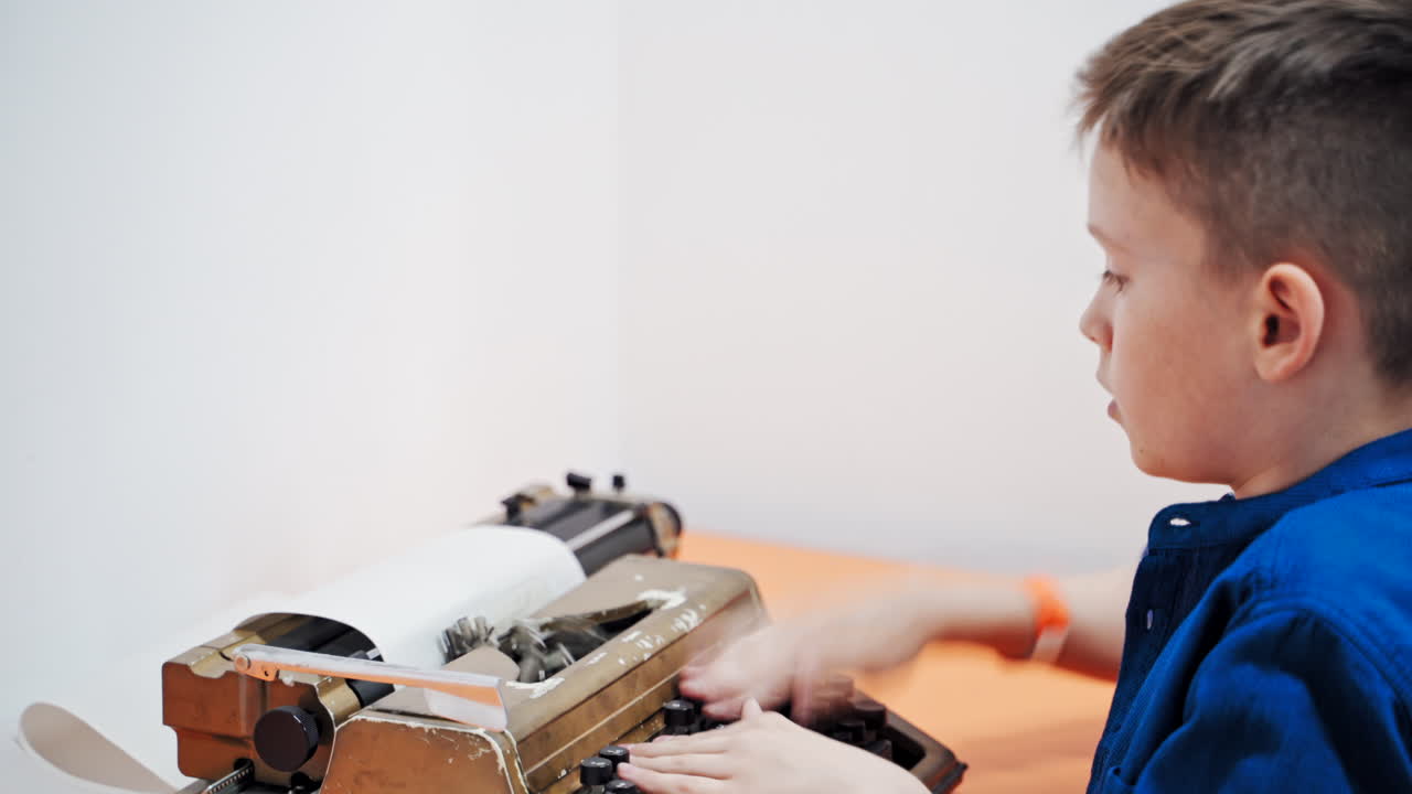 Little boy with the old typewriter, close up