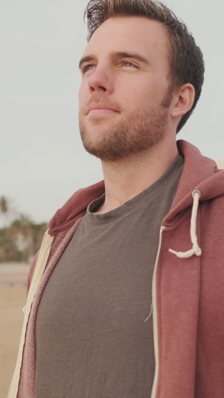 Hombre con sudadera en la playa