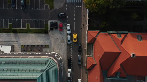 Vista-Aérea-De-Los-Pájaros-Vista-De-Arriba-Hacia-Abajo-Del-Coche-Deportivo-Amarillo-Que-Da-Marcha-Atrás-En-La-Calle-Angosta-Del-Centro-De-La-Ciudad.-Varsovia,-Polonia