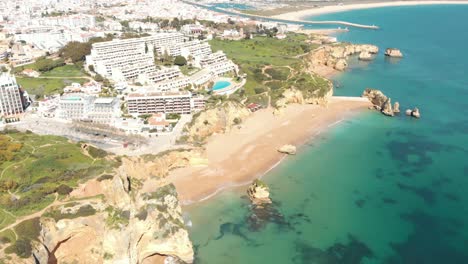 Top-view-over-stunning-Dona-Ana-sandy-beach-in-Idyllic-Lagos-shoreline,-in-Algarve,-Portugal---Aerial-high-fly-over-shot