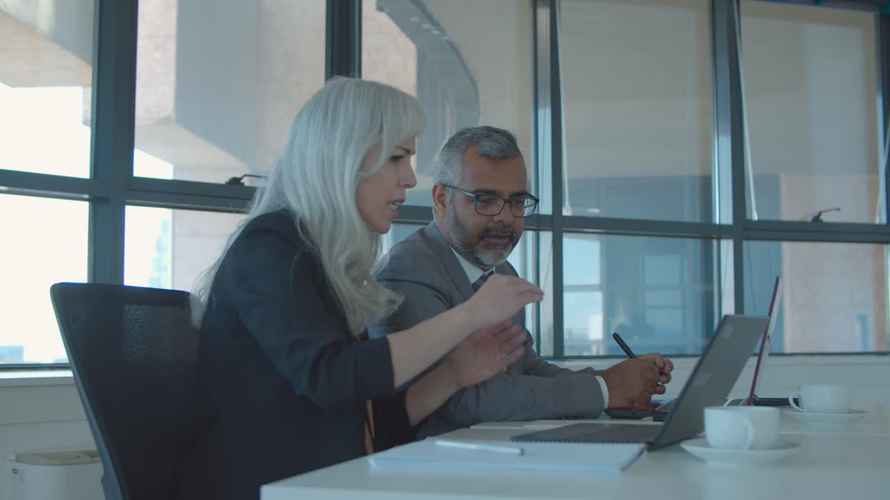 coppia di partner commerciali che guardano e discutono la presentazione