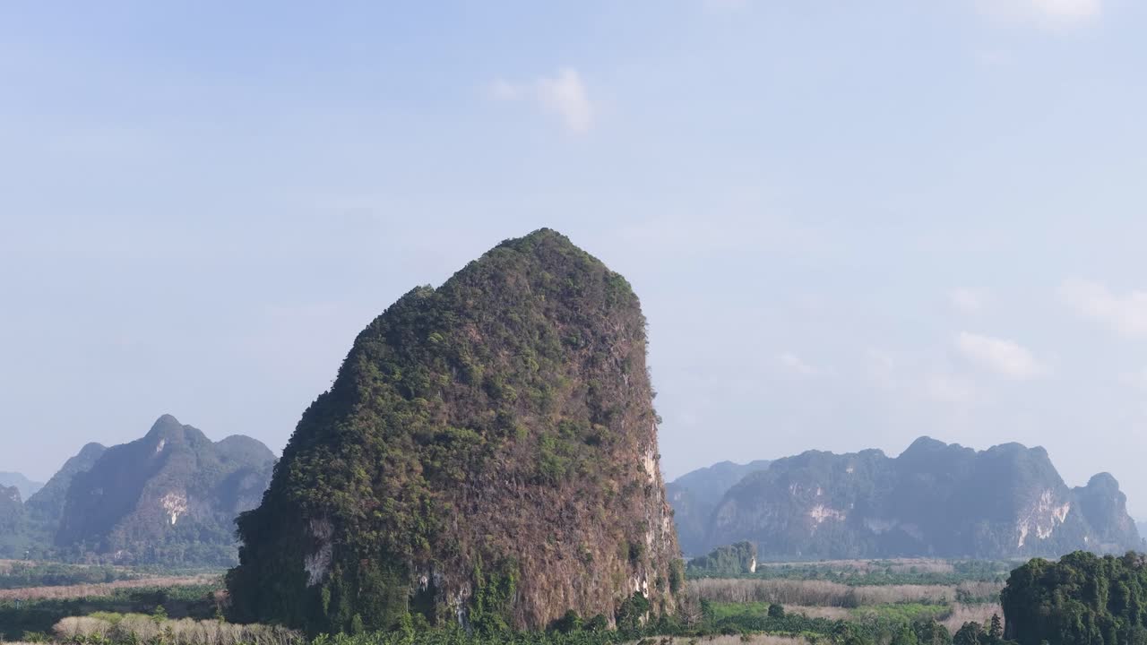Ảnh chụp từ trên không bằng drone với góc rộng cảnh các vách đá vôi và núi nhiệt đới dưới bầu trời xanh trong