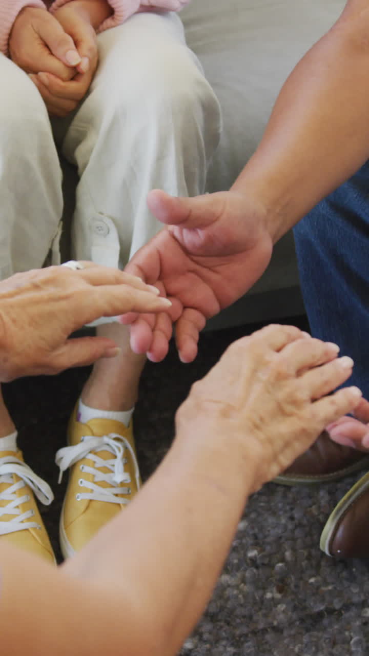 personas de edad avanzada diversas en una reunión tomados de la mano en un hogar de ancianos