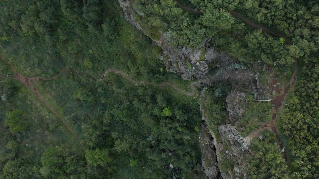 escaleras empinadas que suben por la pared de roca volcánica en el cañón de asbyrgi, islandia, de arriba hacia abajo