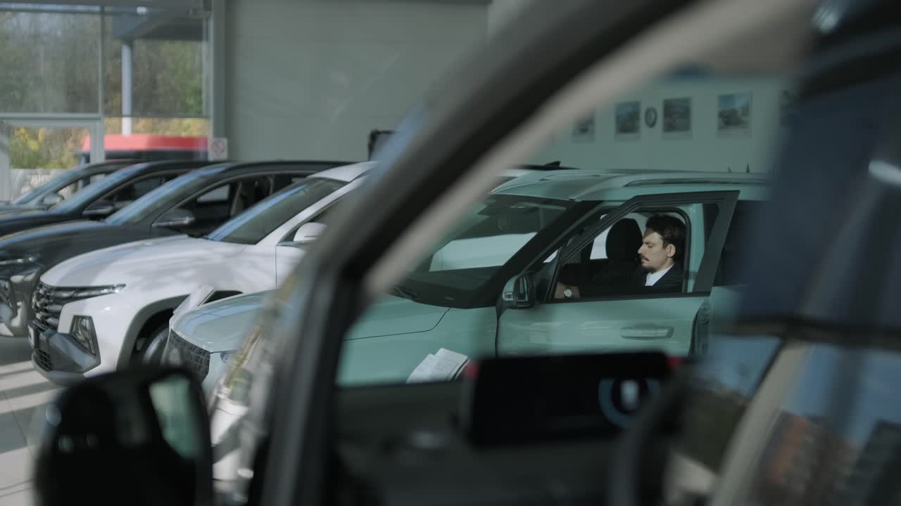 Cars in a Dealership Showroom with Man in Suit