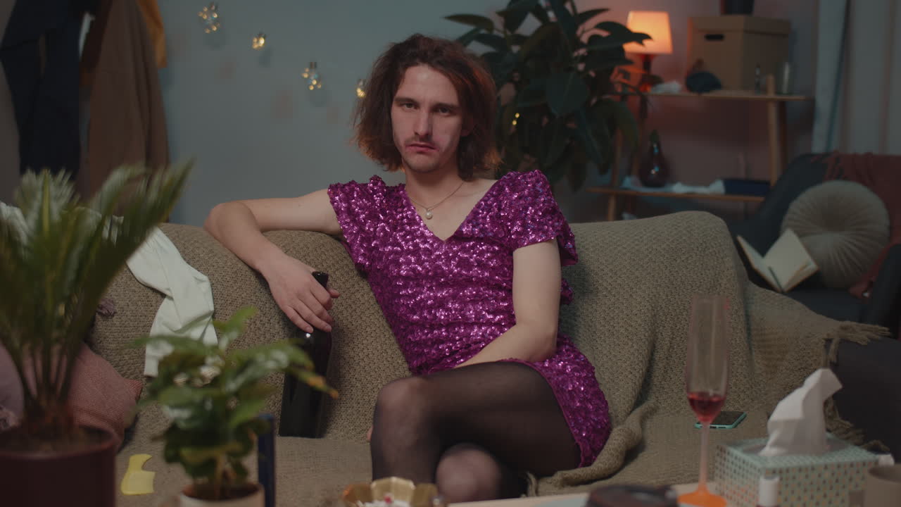 A man in a dress sitting on a couch