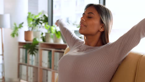 mujer, relájate y sonríe en el sofá de la sala de estar