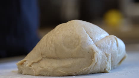 a large lump of dough falling from a mixing bowl to the table for kneading - slow motion