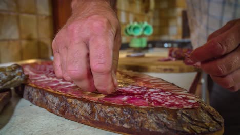 Hands-arranging-sausage-on-wooden-cutting-board