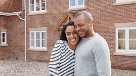retrato de una pareja con llaves de pie fuera de su nueva casa el día de la mudanza