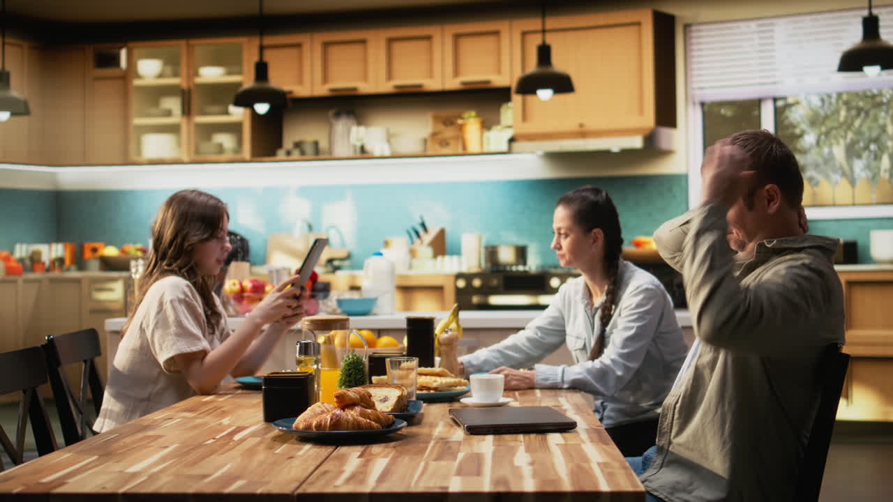 Drained weary working dad typing on laptop during breakfast