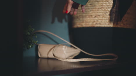 Hand-of-woman-with-red-nails-puts-bag-on-shelf-carelessly