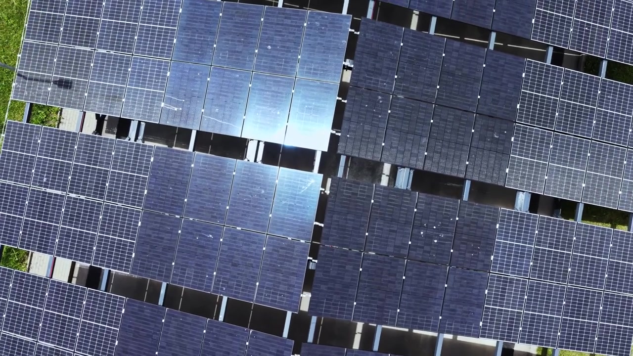 Pannelli solari disposti a griglia su un tetto sotto il sole pomeridiano, che catturano la luce solare per l'energia