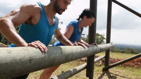 Fit-man-and-woman-doing-pushup-during-obstacle-course