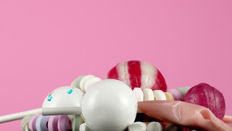 isolated against a bright pink backdrop, a portion of tasty children's candy rotates slowly on a platter