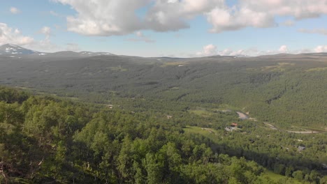 Aerial-drone-flying-over-forrest-with-scenic-mountain-landscape