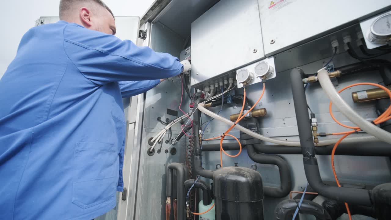 il tecnico controlla le linee elettriche dello scambiatore di calore con le pinze di corrente