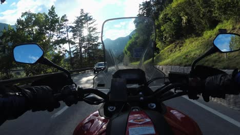 pov biker rides a motorcycle on a scenic sunny mountain road, austria