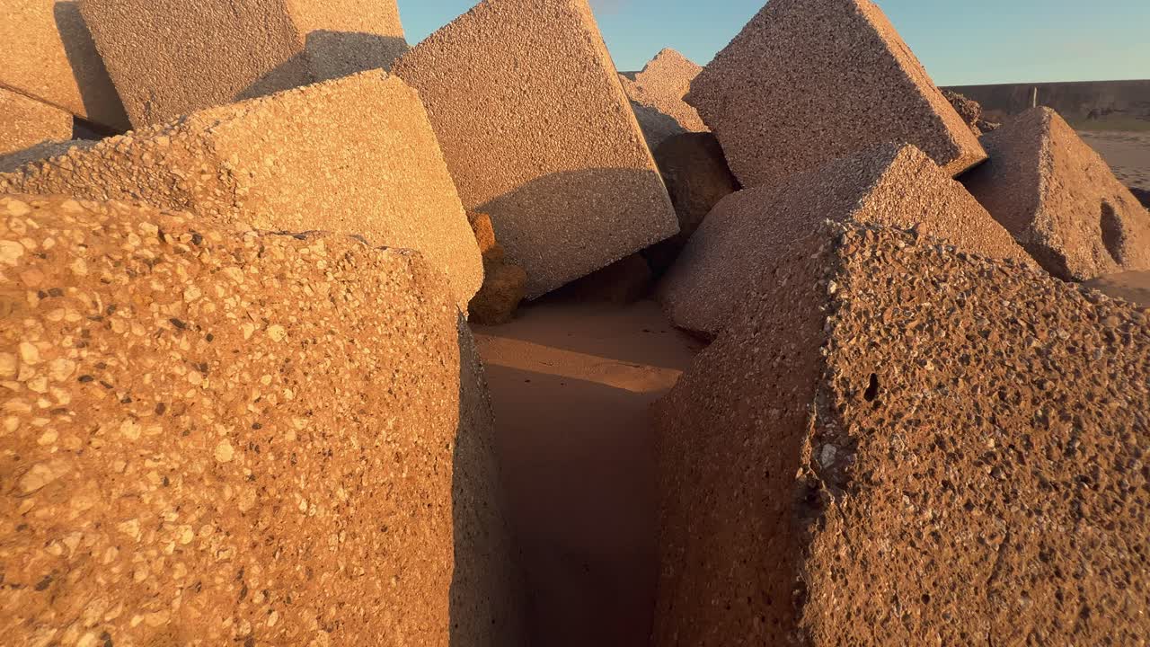 Moving along robust cubicles lining the beach, serving as a defense against erosion