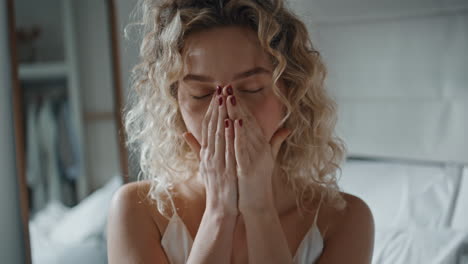 Girl massaging hand cream in morning light closeup. Serene curly lady enjoying