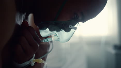 male patient in oxygen mask breathe crossing arms in intensive care unit closeup