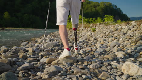 person with prosthetic leg hiking by a river