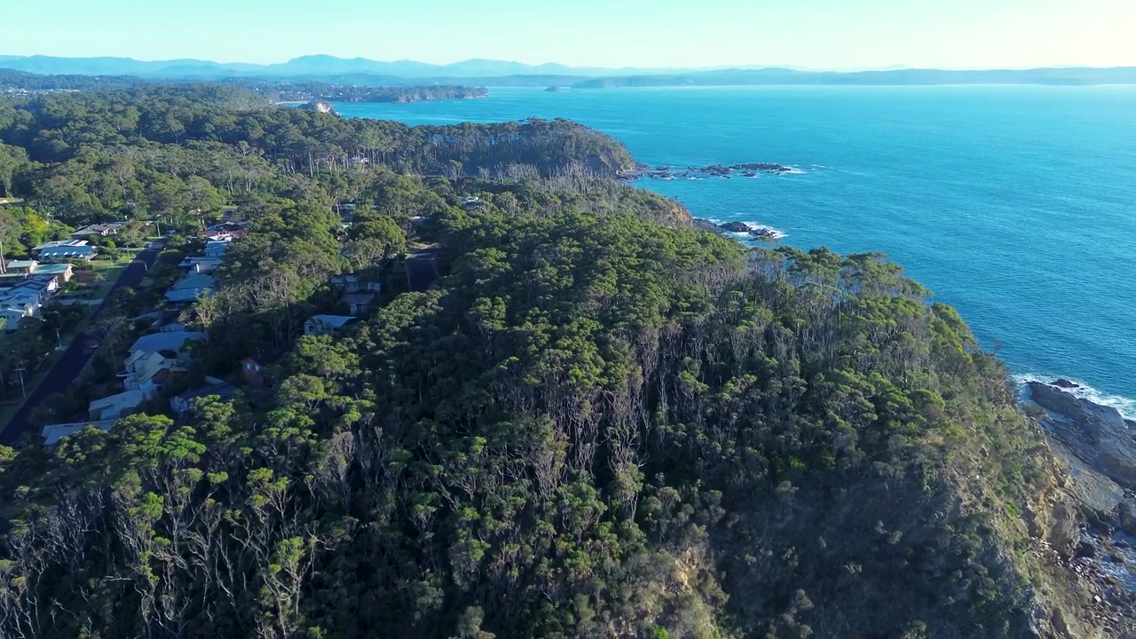 Drone luftlandskab af landlige byhuse blandt skov og buskads i nationalpark langs kystlinjens forbjerg ved Malua Bay og Lilli Pilli Strand på Sydkysten NSW Australien natur og turisme.