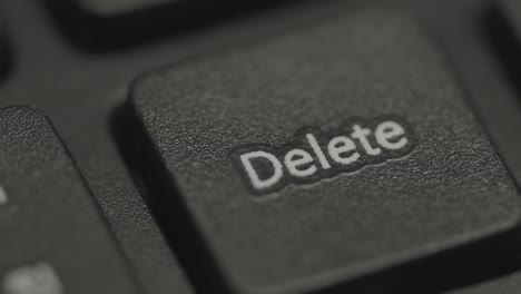 cerca de la mano presionando la tecla de borrar del teclado de la computadora. alemania.
