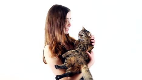 young woman holding a cute cat on her hands at the white background