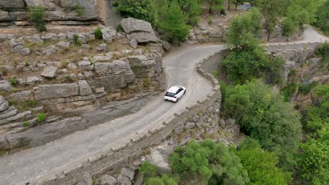 white car on a winding mountain road