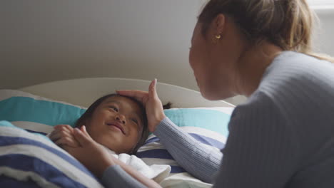 Madre-Asiática-Hablando-Con-Su-Hija-Enferma-En-La-Cama-Antes-De-Irse-A-Dormir