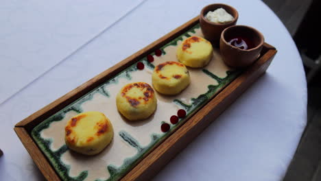 Köstliche-Syrniki-Mit-Saurer-Sahne-Und-Marmelade,-Frühstücks-Mini-Hüttenkäse-Pfannkuchen,-Traditionelles-Ukrainisches-Russisches-Gericht,-Brunch-Restaurant,-4K-Aufnahme