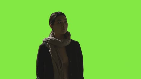 low key studio shot of woman looking all around frame against green screen in vr environment