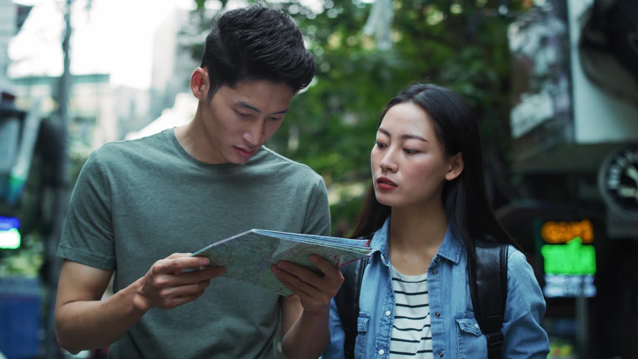 Handheld view of couple using map while sightseeing