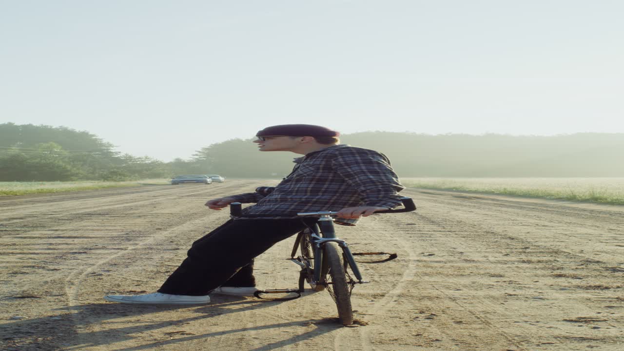 해가 뜨는 시골 풍경에서 자전거를 타고 있는 남자