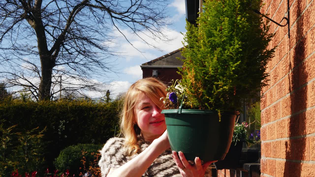 정원에서 꽃 바구니를 보는 매력적인 행복한 여성 중간 4k 중간  ⁇  느린 동작 초상화